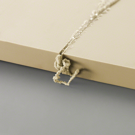 밝은 색 판자에 뚫은 구멍에서 튀어나온 과도한 재료 잔여물.