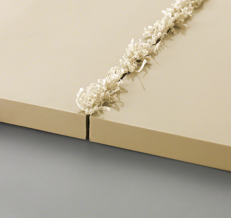 새롭게 홈이 파인 베이지색 패널 두 개와 가장자리를 따라 말려 올라간 나무 조각들.