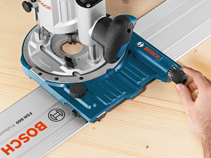 한 사람이 나무 표면 위에서 시스템 액세서리 트랙 가이드를 조정하고 있습니다.