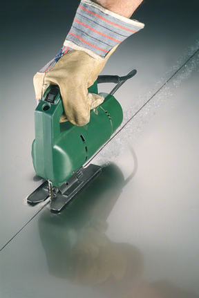 안전장비를 착용한 사람이 퍼즐을 사용해 금속을 직선으로 자릅니다.