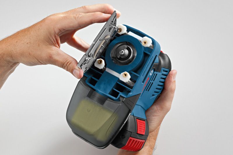 무선 오비탈 샌더의 샌딩 패드를 교체하는 사람.