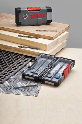 나무판과 금속판 위에 직소톱날 세트가 진열되어 있으며, 날들은 케이스에 정리되어 있습니다.