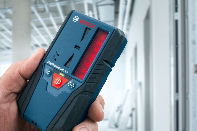 건설 중인 건물에서 레이저 수신기를 들고 있는 사람.