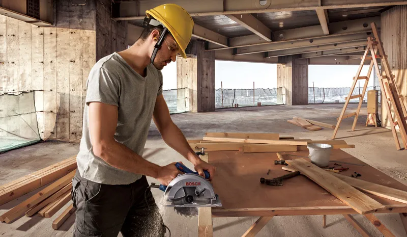 나무판을 톱질하는 노동자.