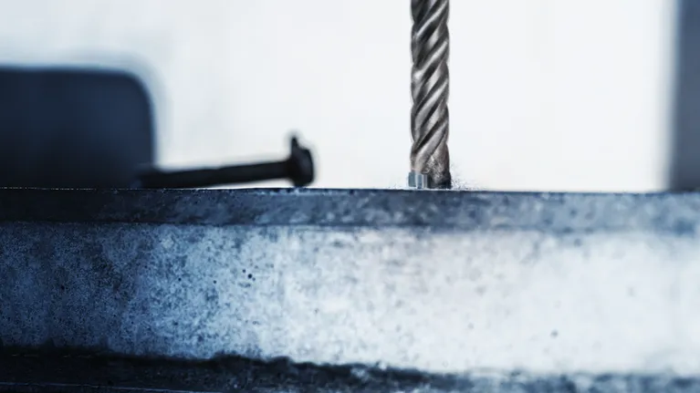 금속 표면에 구멍을 뚫는 회전 드릴 비트입니다.