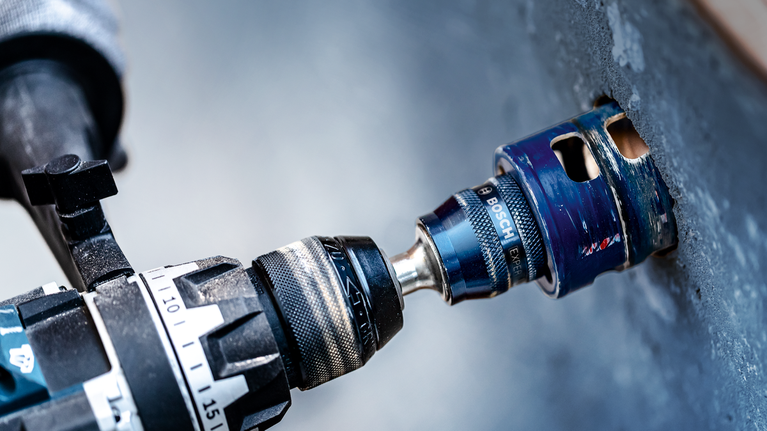 콘크리트 벽에 원형으로 구멍을 뚫기 위해 홀 톱 부착물을 사용합니다.