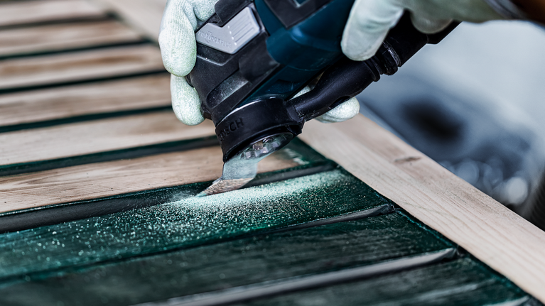 EXPERT Sanding Finger 거친 AVZ 32 RT4 멀티툴 샌딩 플레이트 32 x 53mm 안전 장비를 착용한 사람이 전동 공구로 목재 판자를 연마하고 있습니다.