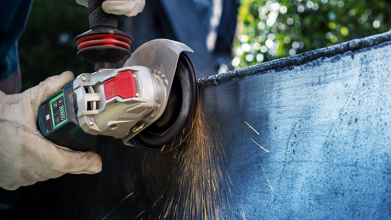 EXPERT R782 Prisma Ceramic 화이버 디스크 100mm, 16mm, G 36 안전 장비를 착용한 사람이 금속을 갈아서 불꽃이 난다.