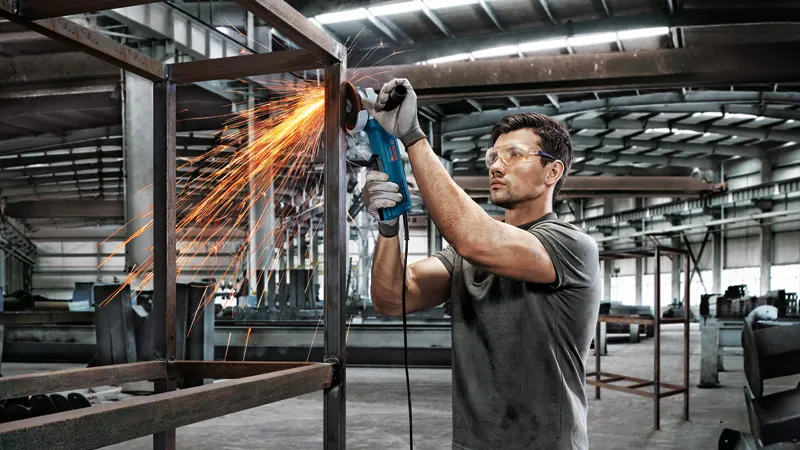 금속 프레임을 갈고 있는 남자.