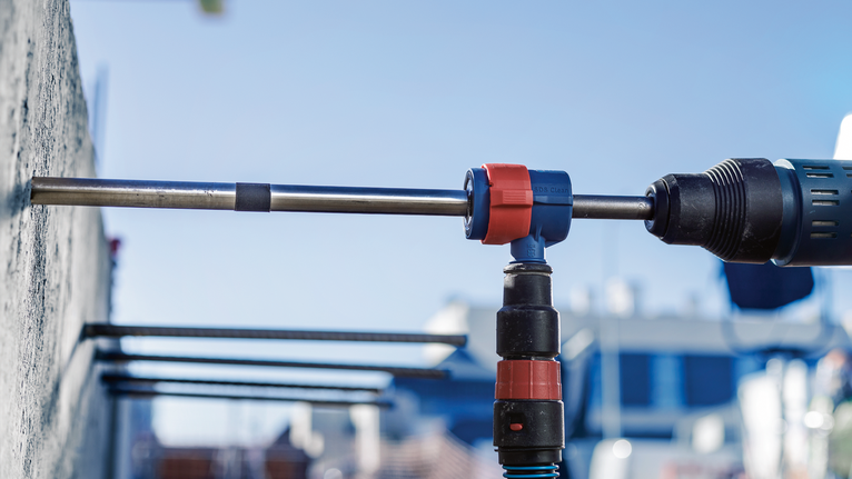 EXPERT SDS Clean plus-8X 해머 드릴 비트 세트 20 x 400 x 550 야외 콘크리트 벽에 회전 해머로 구멍을 뚫는 모습입니다.