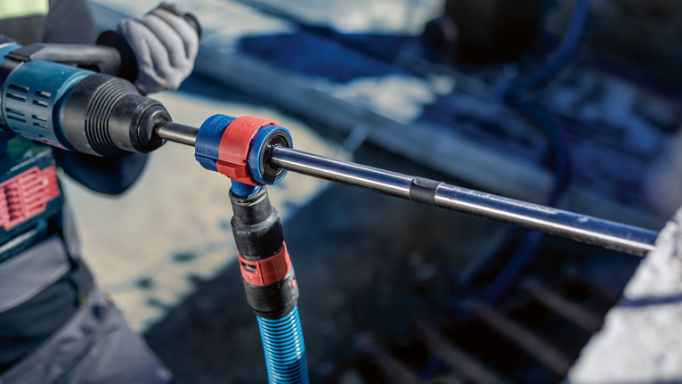 EXPERT SDS Clean plus-8X 해머 드릴 비트 세트 20 x 400 x 550 안전 장비를 착용한 사람이 회전 도구를 사용하여 콘크리트에 구멍을 뚫고 있습니다.