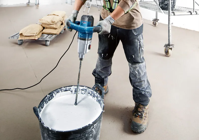 GRW 140 안전장비를 착용한 사람이 전동 교반장치를 이용해 페인트를 섞고 있습니다.