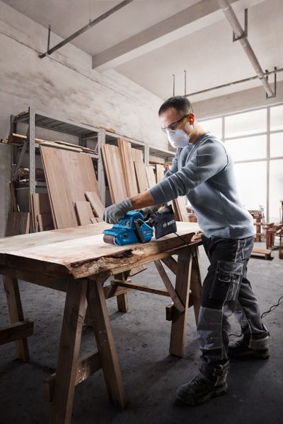 Bosch GBS 750 벨트 샌더로 나무 판자를 매끄럽게 다듬습니다.