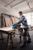Bosch GBS 750 벨트 샌더로 나무 판자를 매끄럽게 다듬습니다.
