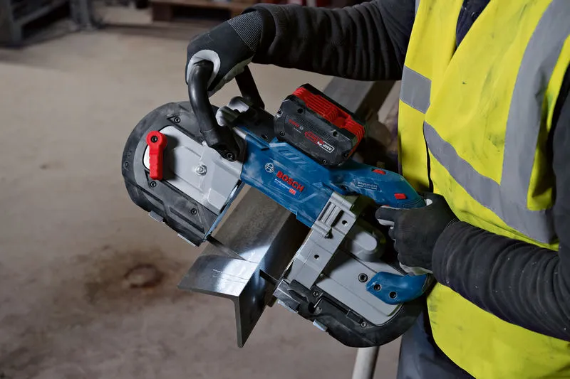 안전 장비를 착용한 사람이 무선 밴드톱을 사용하여 금속 빔을 자릅니다.