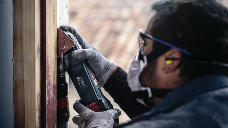 PRO F460 샌딩 시트, 93 x 93mm, G60, G80, G120, G180, G240, 10개 안전 장비를 착용한 사람이 전동 공구를 이용해 나무 프레임을 연마하고 있습니다.