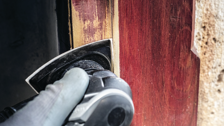 PRO F460 샌딩 시트, 93 x 93mm, G60, G80, G120, G180, G240, 10개 안전 장비를 착용한 사람이 전동 공구로 나무 문틀을 연마하고 있습니다.