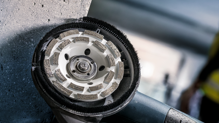 PRO Concrete 연마 헤드, 50 x 125mm, 22.23mm 다이아몬드 연삭 휠로 콘크리트 벽을 매끄럽게 다듬는 모습입니다.