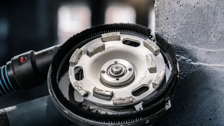 다이아몬드 컵 휠은 수직 표면의 콘크리트를 분쇄합니다.