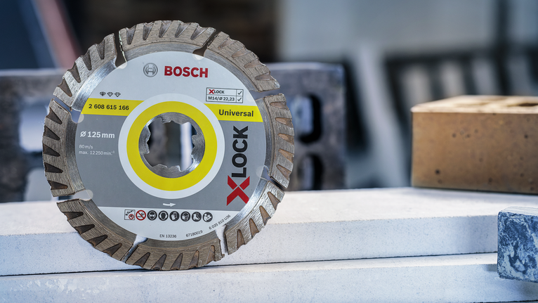 쌓아 놓은 건축 자재 위에 다이아몬드 톱날이 놓여 있습니다.