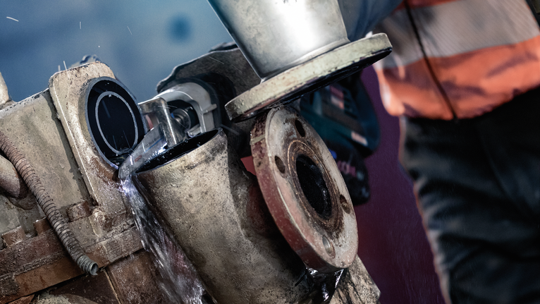 PRO Thick Metal Demolition S930CF 날, 1.6 x 22 x 150mm, 5개 안전 장비를 착용한 사람이 분쇄기를 사용해 물로 식히는 금속 파이프를 절단하고 있습니다.