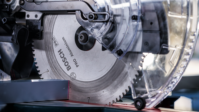 PRO Aluminium cordless 원형 톱날, 254 x 2.4 x 30mm 작업장에서 원형 톱날로 금속 조각을 자르는 모습.