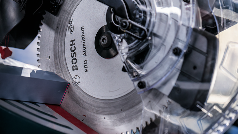 PRO Aluminium cordless 원형 톱날, 254 x 2.4 x 30mm 투명한 톱날 보호대가 있는 원형 톱날의 클로즈업.