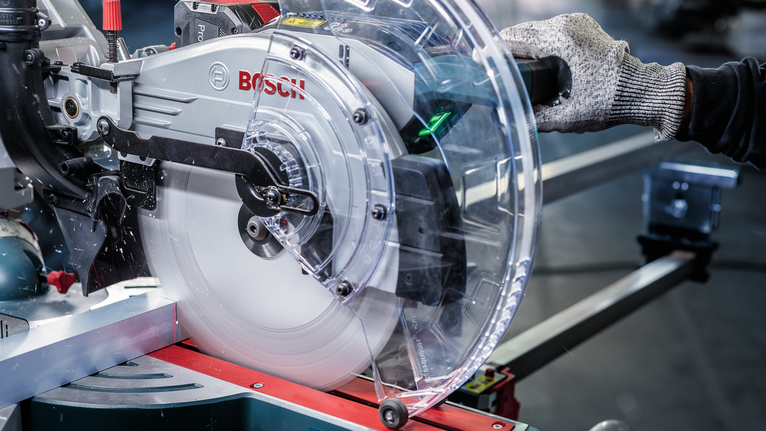 PRO Aluminium cordless 원형 톱날, 254 x 2.4 x 30mm 안전 장비를 착용한 사람이 금속 절단 작업대에서 원형 톱을 조작하고 있습니다.