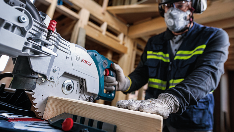 PRO Wood cordless 원형 톱날, 254 x 2.2 x 30mm, T24 안전 장비를 착용한 사람이 원형 톱을 조작하여 나무 들보를 자르고 있습니다.