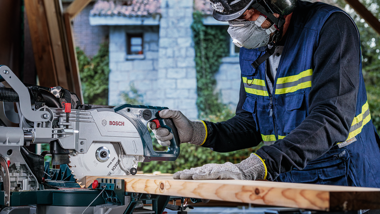 PRO Wood cordless 원형 톱날, 254 x 2.2 x 30mm, T24 안전장비를 착용한 사람이 전기톱으로 나무를 자르고 있습니다.