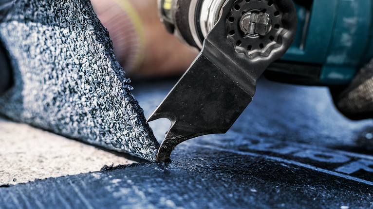 PRO ASZ 32 SC 멀티커터 날, 24 x 11mm 안전 장비를 착용한 사람이 전동 공구를 사용하여 바닥재를 자르고 있습니다.