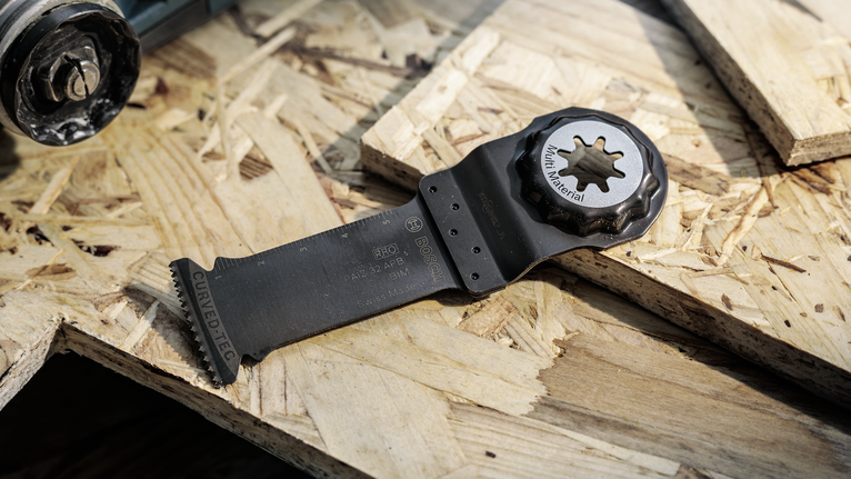 나무판 위에 놓인 진동하는 멀티툴 칼날.