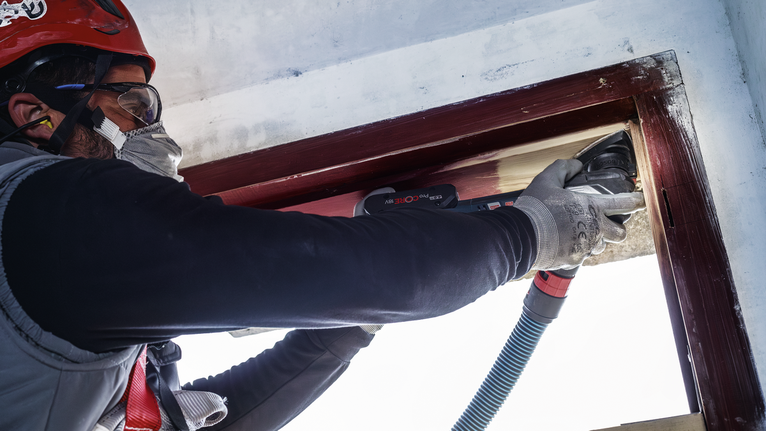 PRO AVZ 93 G 멀티커터 액세서리, 93mm 안전 장비를 착용한 사람이 전동 공구로 나무 창틀을 연마하고 있습니다.