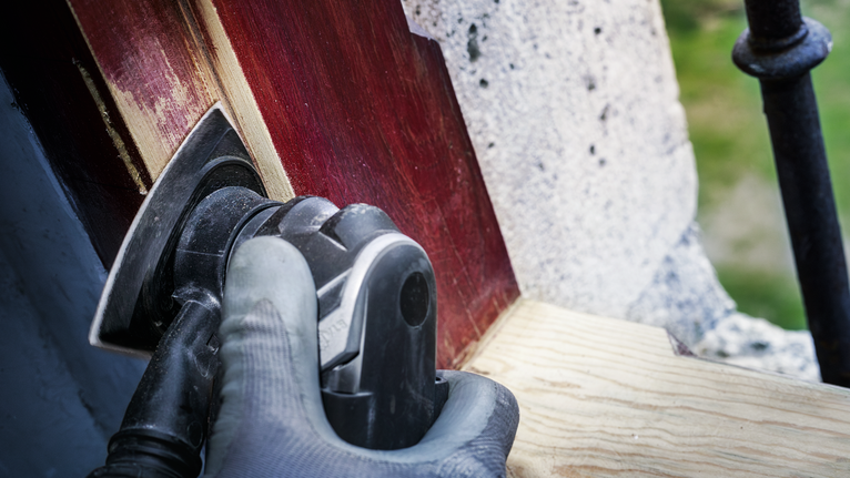 PRO AVZ 93 G 멀티커터 액세서리, 93mm 안전 장비를 착용한 사람이 전동 공구를 이용해 페인트칠한 목재를 연마하고 있습니다.