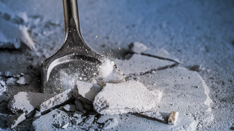 건설 현장에서 콘크리트 잔해를 끌로 부수는 모습.