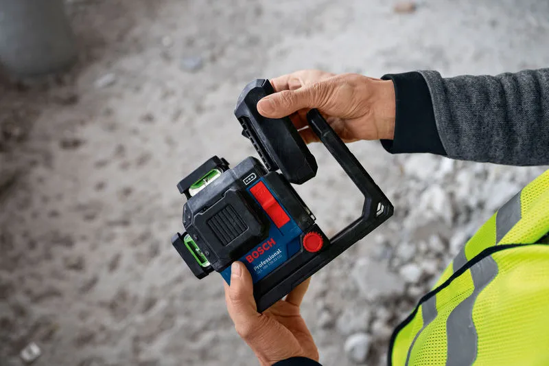 안전 장비를 착용한 사람이 건설 현장에서 레이저 레벨링 도구를 조정하고 있습니다.