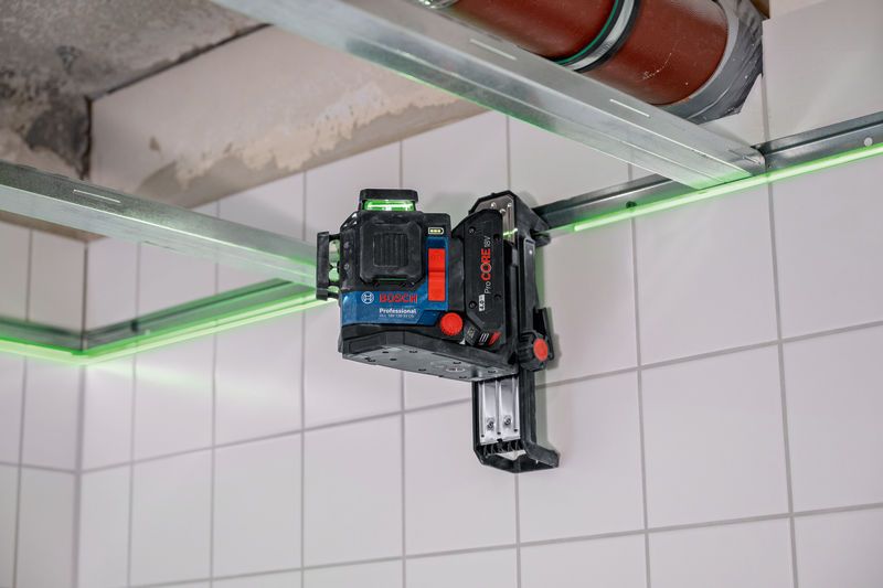벽면 트랙 액세서리에 장착된 레이저 레벨링 도구는 타일 벽에 녹색 선을 투사합니다.
