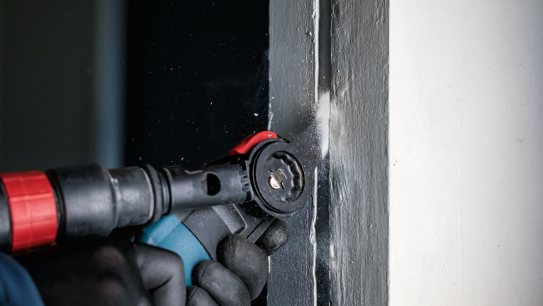 PRO MAII 32 SC 멀티커터 날, 32 x 55mm 안전 장비를 착용한 사람이 전동 공구를 사용하여 문틀을 자릅니다.