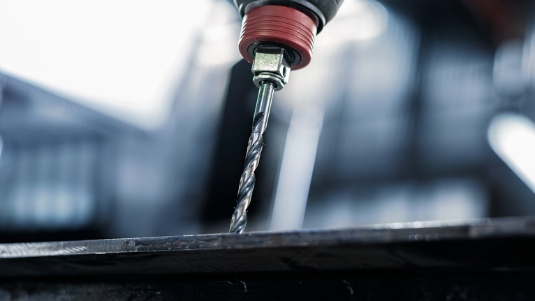 금속판에 구멍을 뚫는 전동 드릴.