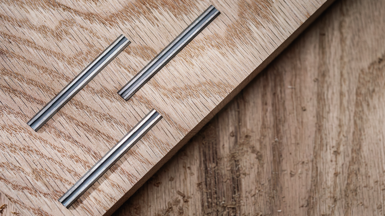 가벼운 나무판에 홈이 있는 금속 인레이 3개가 박혀 있습니다.