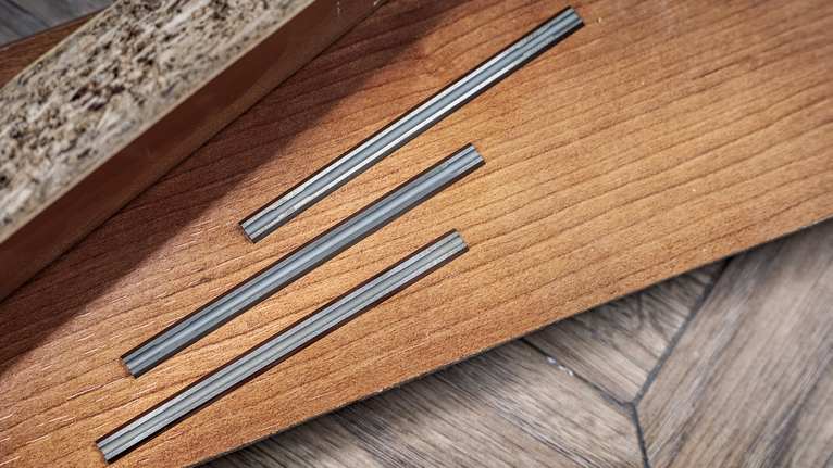 마루 바닥의 나무판에 세 개의 평행한 홈이 파여 있습니다.