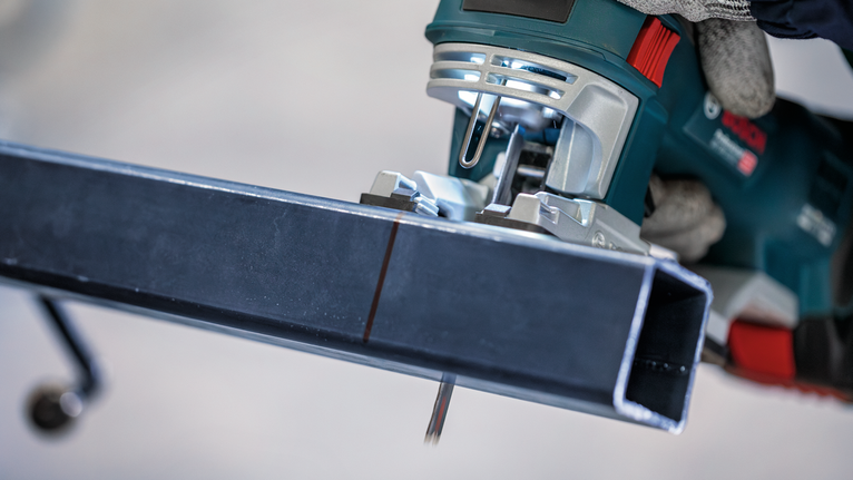 PRO Metal Pipes and Profiles T321AF 직쏘날, 132mm, 5개 안전 장비를 착용한 사람이 퍼즐을 사용하여 금속 막대를 자릅니다.