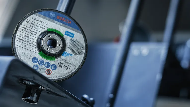 작업장의 금속 도구에 장착된 절단 디스크의 클로즈업.