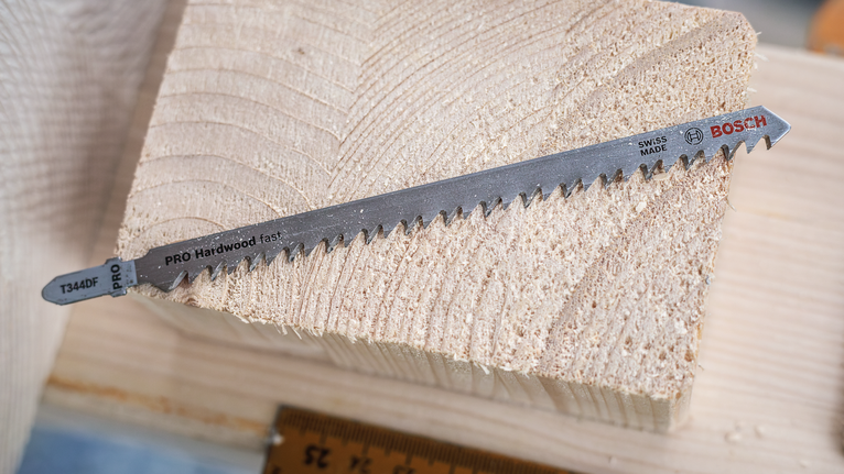 PRO Hardwood fast T344DF 직쏘날, 152mm, 5개 잘린 나무 블록 위에 놓인 퍼즐 칼날.