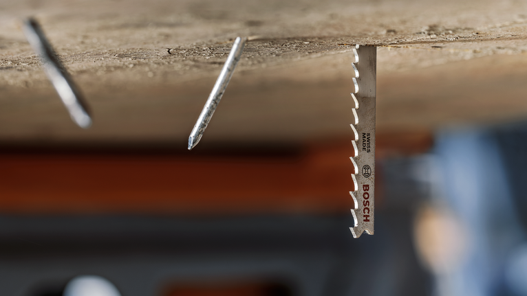 두 개의 튀어나온 못 옆에 나무에 설치된 금속 톱날.