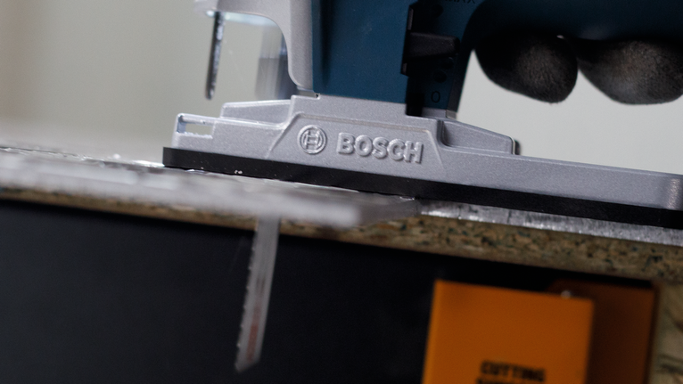 PRO Alu T127D 직쏘날, 100mm, 5개 안전 장비를 착용한 사람이 퍼즐을 이용해 나무판을 자르고 있습니다.