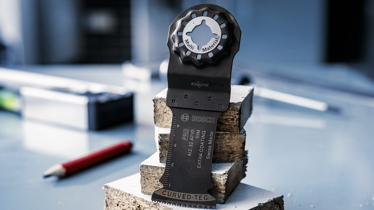 작업장의 쌓인 콘크리트 블록 위에 진동 톱날이 똑바로 세워져 있습니다.