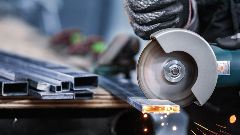 PRO Stainless Steel and Metal 절단석, 105 x 1 x 16mm 안전 장비를 착용한 사람이 각도 분쇄기로 금속을 자르면서 불꽃을 일으킵니다.