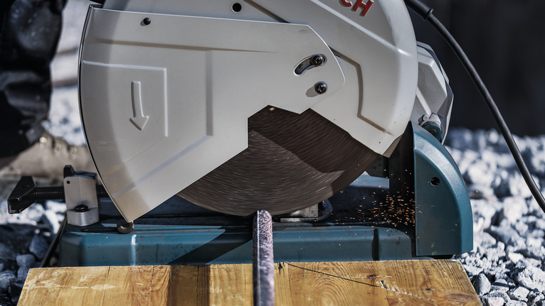 금속 절단 톱으로 철근을 자르면 나무 표면에 불꽃이 생깁니다.