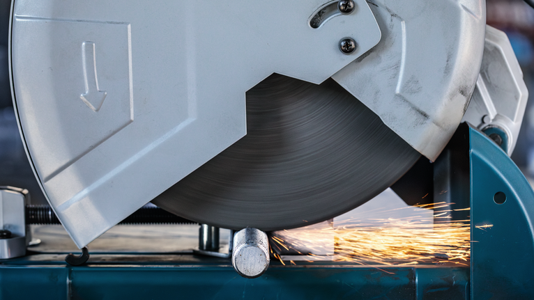 금속 절단 톱이 파이프를 자르며 밝은 불꽃을 튀겼습니다.